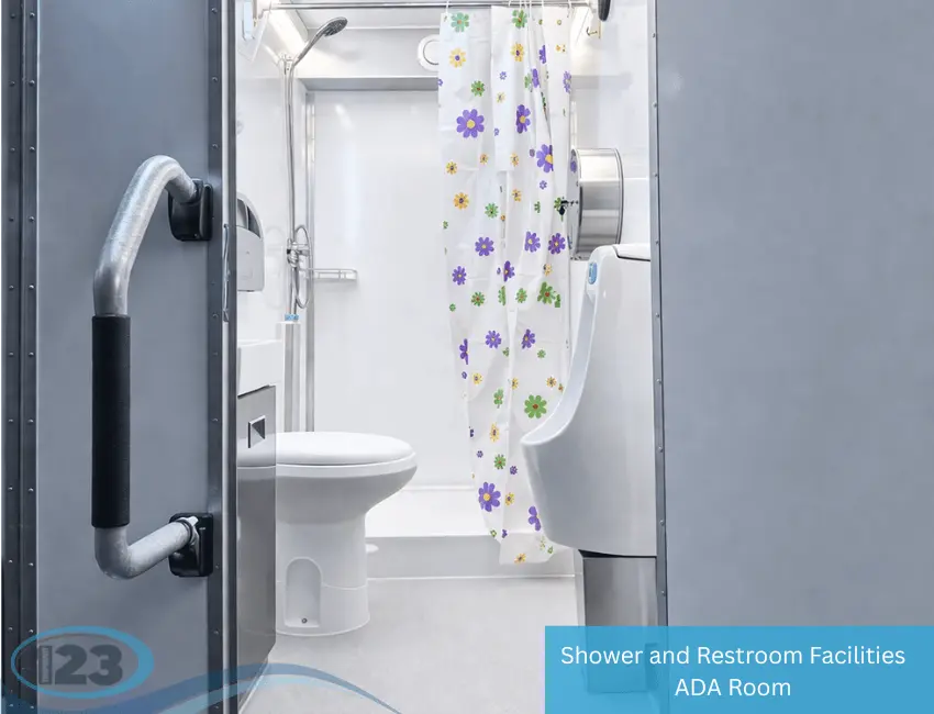 Interior of mobile shower and restroom trailer with toilet, urinal, sink, and shower curtain